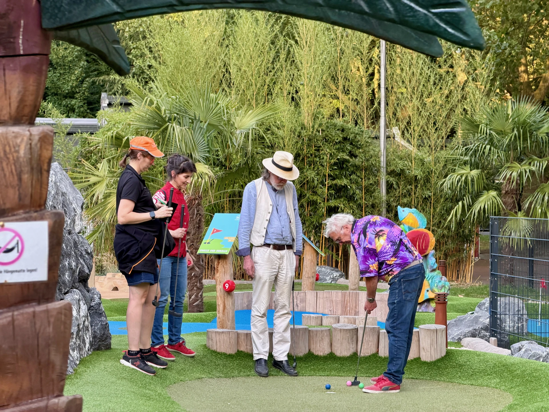 Vier Personen beim Minigolf